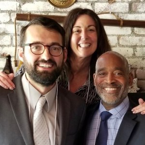 two men and a woman posing together for photo